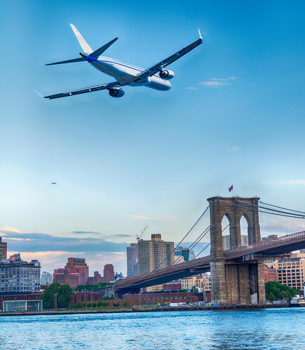 Airplane flying over Brooklyn Bridge