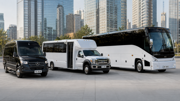 Three passenger buses of different sizes parked on a plaza with city skyscrapers in the background of a sunny day.